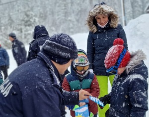 Policjant rozdaje dzieciom ulotki