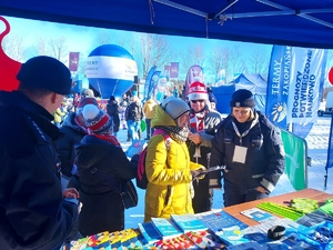 Policjanci przy namiotach profilaktycznych rozmawiają z osobami dorosłymi o bezpieczeństwie.