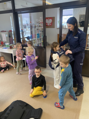 policjantka z wydziału prewencji zakłada kamizelke